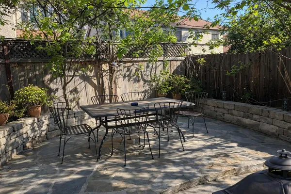 a view of outdoor dining space with a backyard and trees