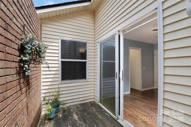 a view of a porch with a door and wooden floor