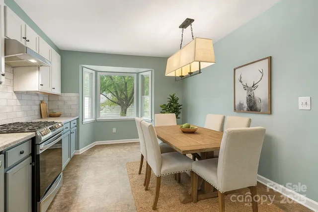 a dining room with wooden floor a chandelier a wooden table and chairs
