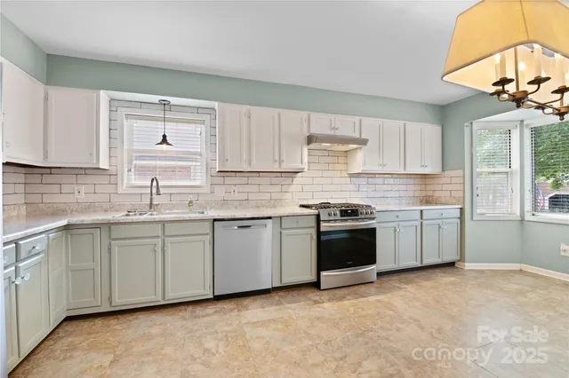 a kitchen with stainless steel appliances granite countertop a stove sink and cabinets