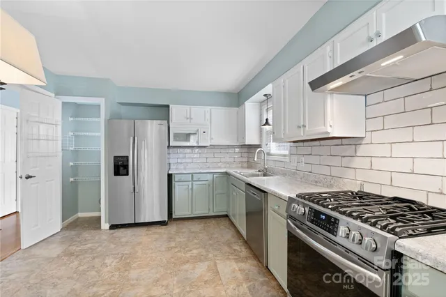 a kitchen with refrigerator stove and sink