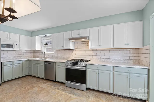 a kitchen with white cabinets stainless steel appliances and sink