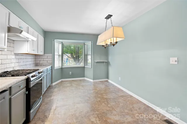 a large kitchen with a stove and a chandelier