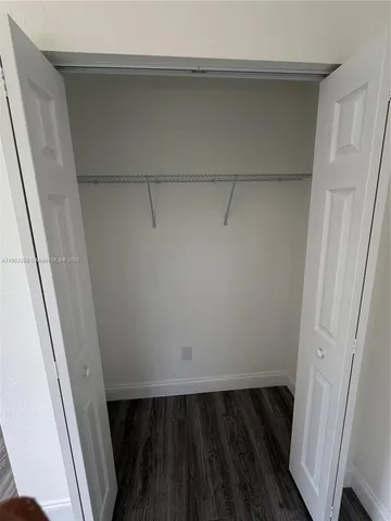 a view of walk in closet with wooden floor