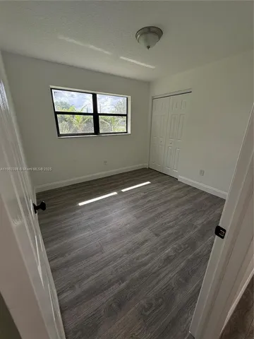 a view of a room with wooden floor and window