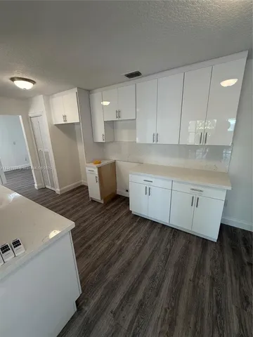 a living room with hard wood floors and a sink