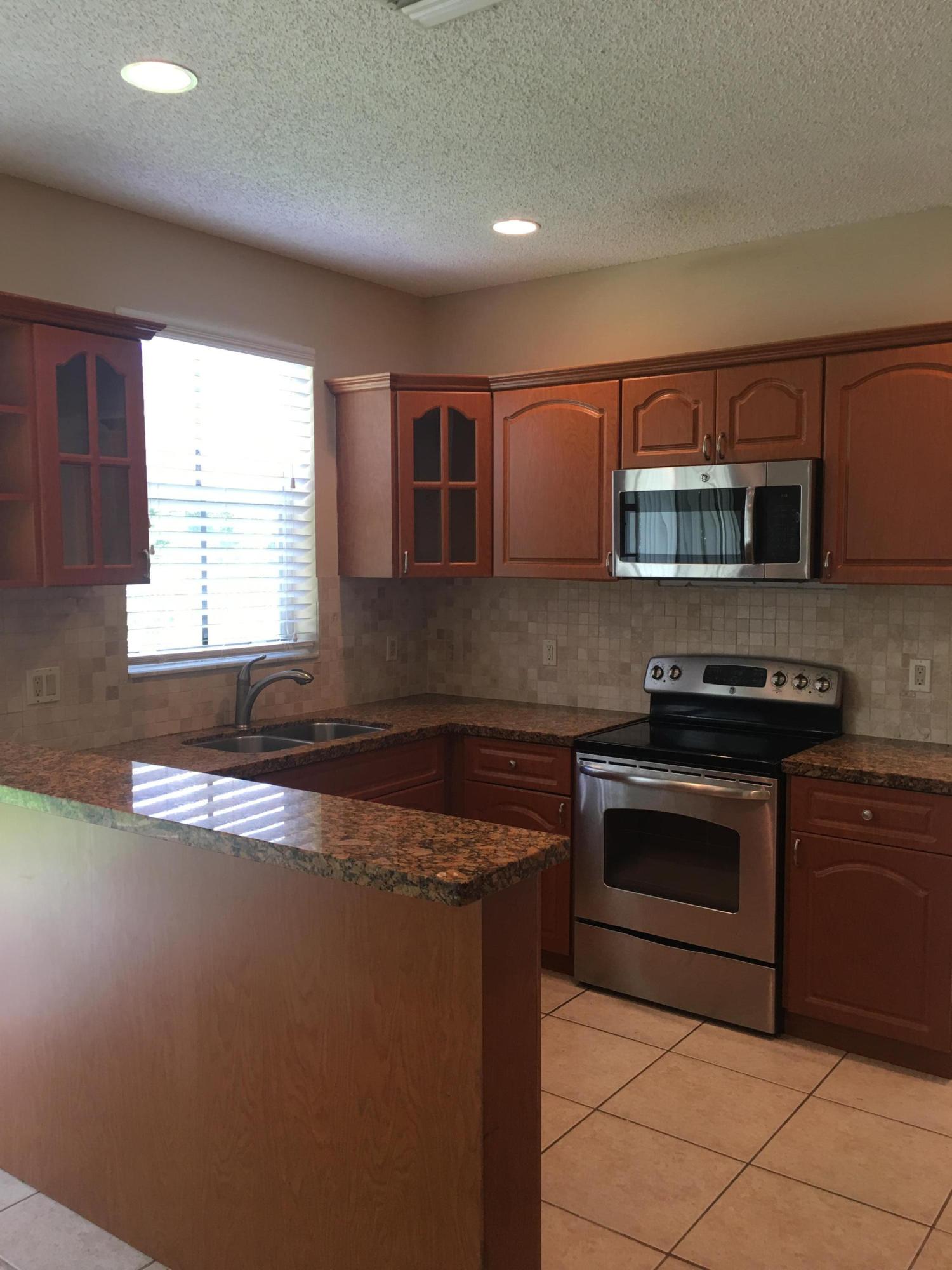 4383 Laurel Ridge Circle Weston, FL 33331 - Photo 6 of 36 a kitchen with stainless steel appliances granite countertop a stove a sink and a microwave