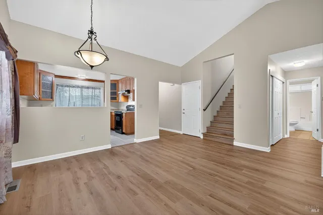 a view of empty room with wooden floor and window