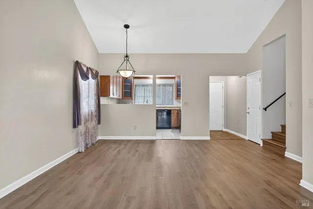 a view of a room with wooden floor staircase and a kitchen