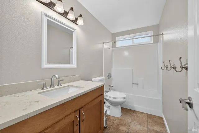 a bathroom with a double vanity sink toilet mirror and shower