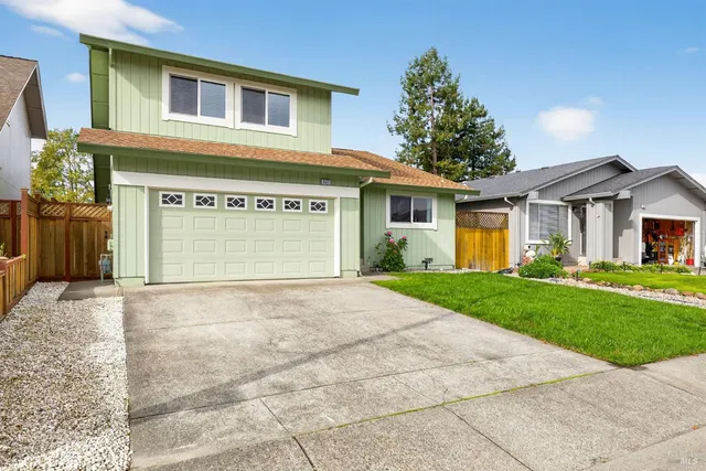 a view of a house with a yard and garage
