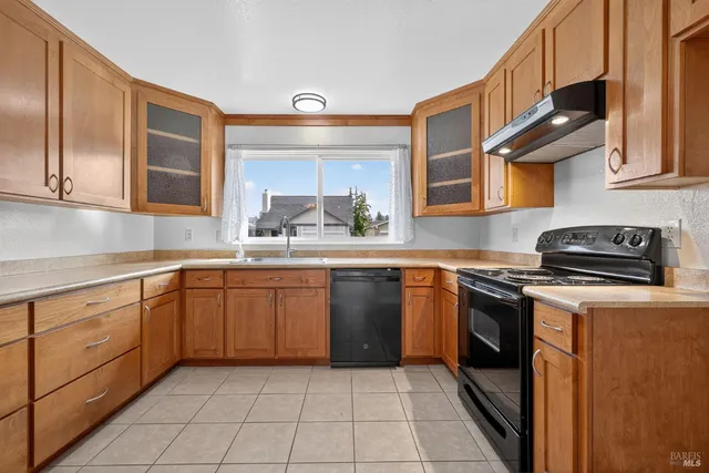 a kitchen with stainless steel appliances granite countertop a sink stove and cabinets
