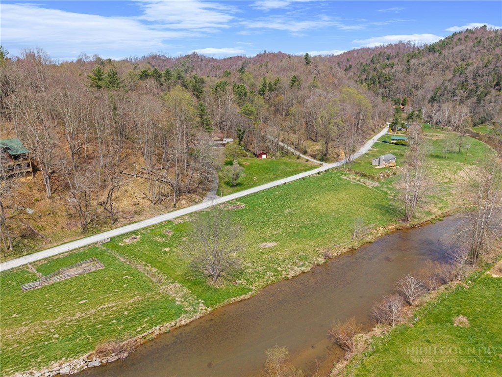 2345 Watauga River Road Sugar Grove, NC 28679 - Photo 1 of 50 a view of a lush green forest with a lake