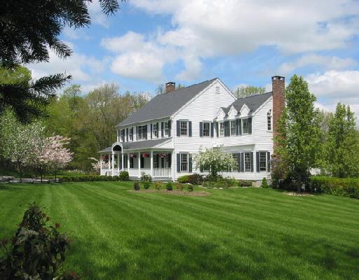 a front view of a house with a garden and trees
