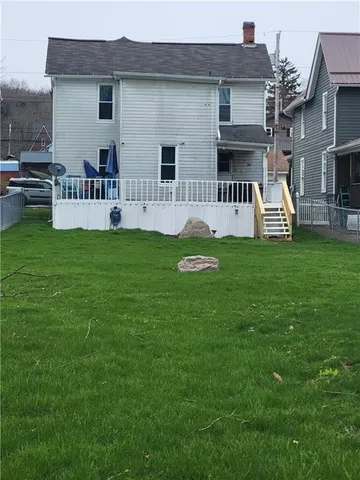 a view of house with a backyard