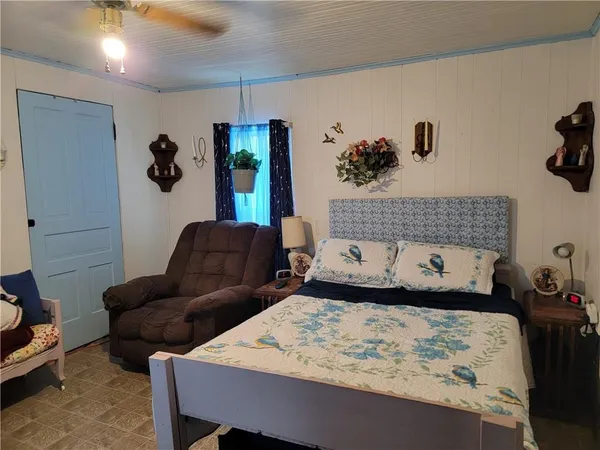 a bedroom with a bed couch and a window