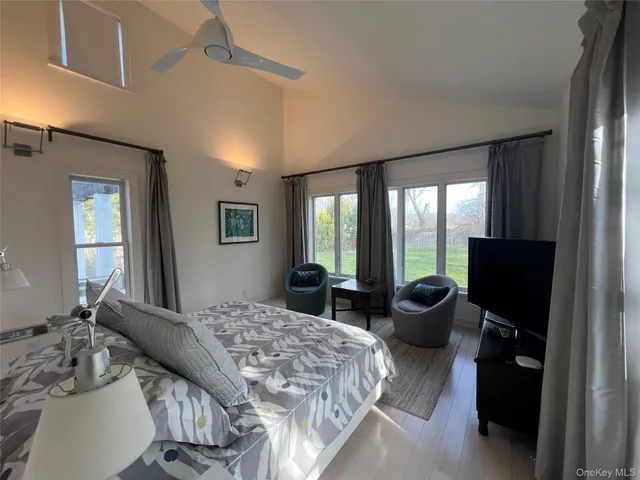 a bedroom with a bed and large windows