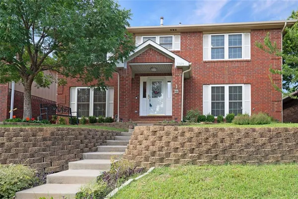 a front view of a house with a yard and potted plants