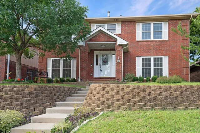 a front view of a house with a yard and potted plants
