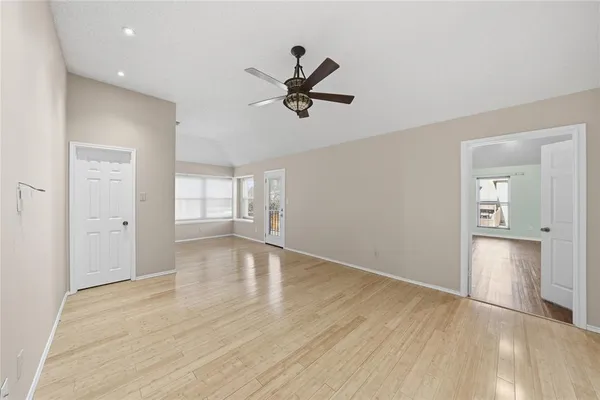 an empty room with wooden floor and windows