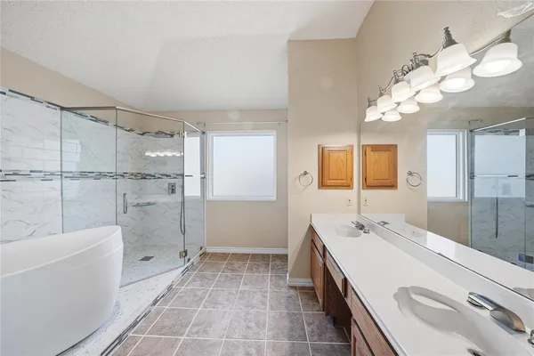 a bathroom with a sink a toilet a mirror and shower