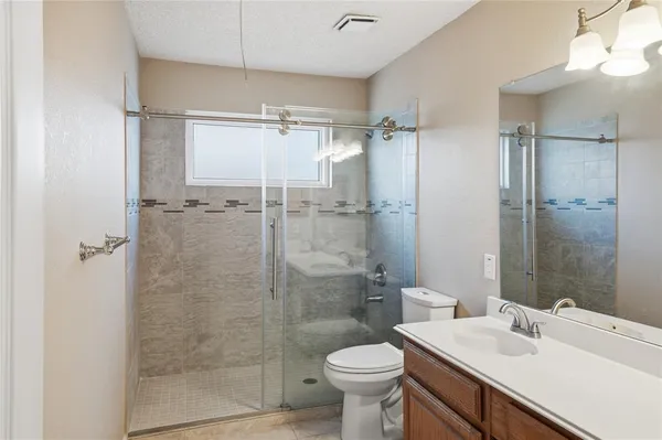 a spacious bathroom with a double vanity sink toilet and shower