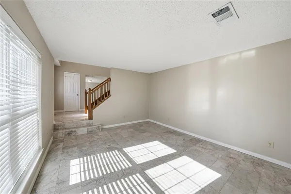 a view of a big room with wooden floor and windows