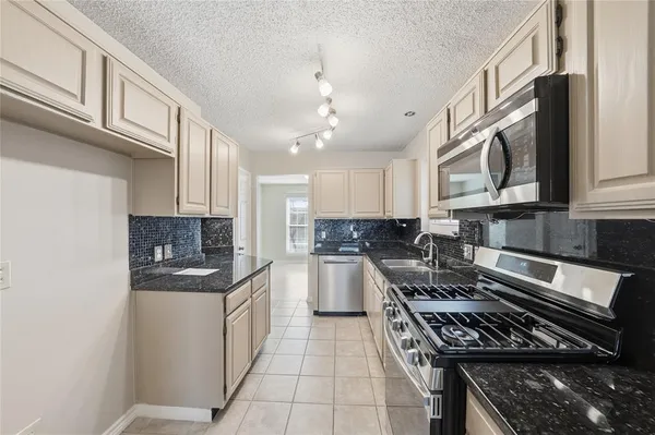 a kitchen with stainless steel appliances granite countertop a stove and a sink