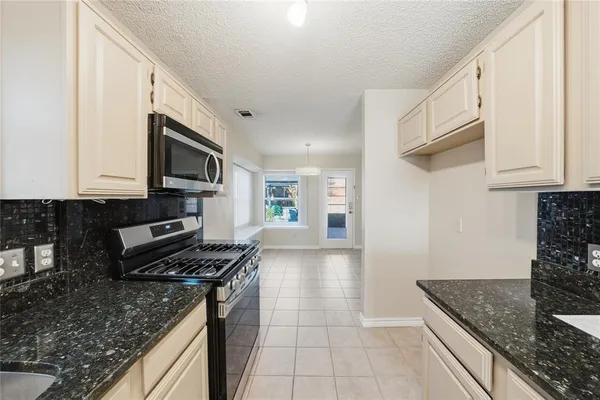 a kitchen with stainless steel appliances granite countertop a sink stove and microwave