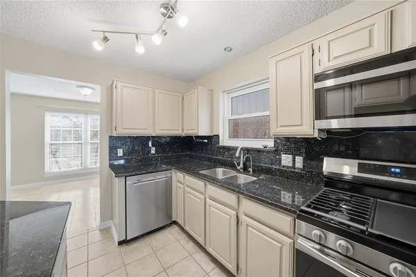 a kitchen with stainless steel appliances granite countertop a sink stove and cabinets
