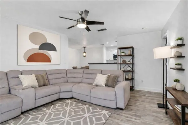 a living room with furniture and a ceiling fan