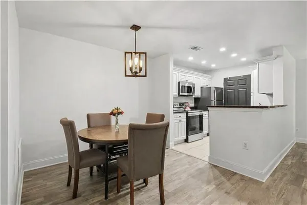 a dining room with furniture and kitchen view