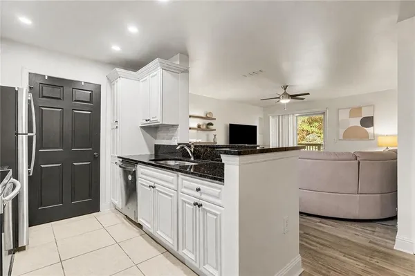a kitchen with granite countertop a refrigerator stove and sink