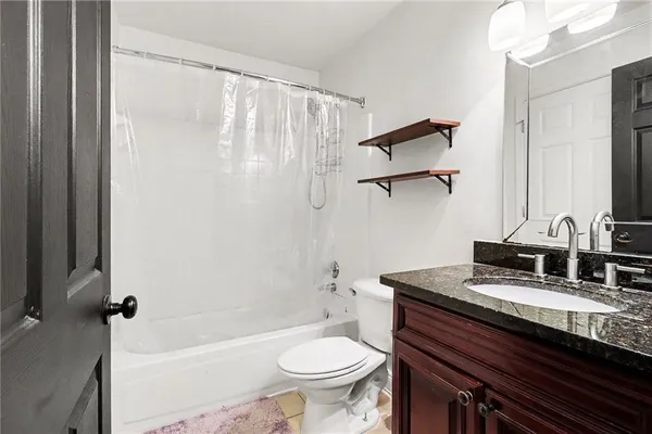 a bathroom with a granite countertop sink toilet and shower