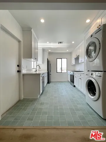 a view of a kitchen with washing machine and utility