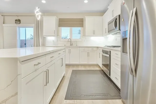 a kitchen with white cabinets and sink