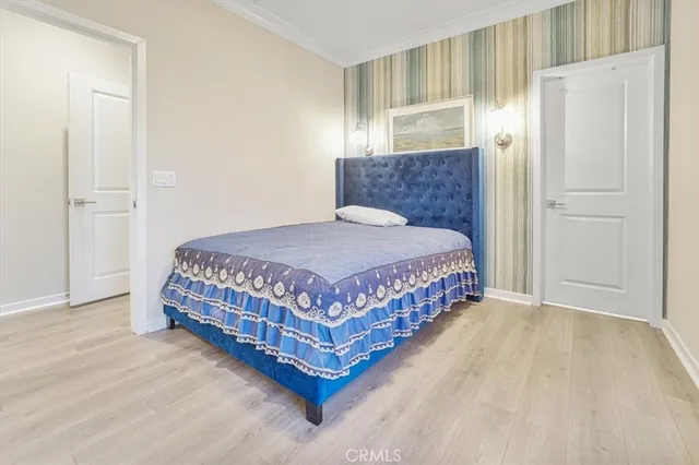 a bedroom with a bed lamp and a refrigerator