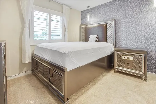 a spacious bedroom with a bed and a chandelier