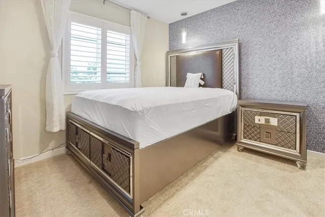 a spacious bedroom with a bed and a chandelier