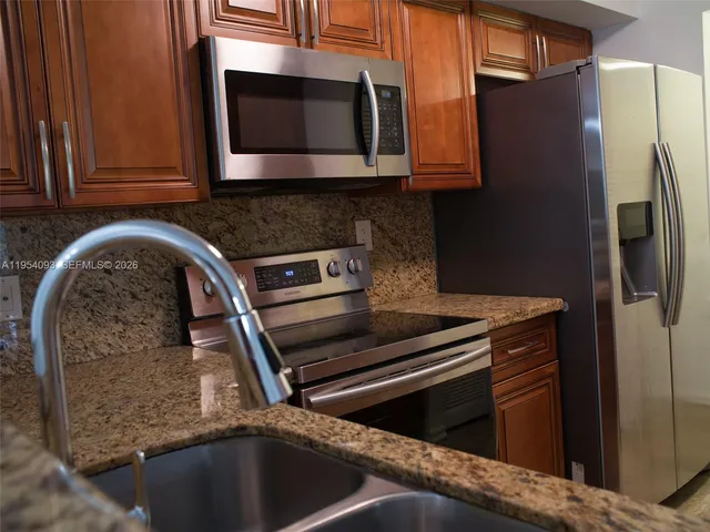 a kitchen with granite countertop a stove and a microwave