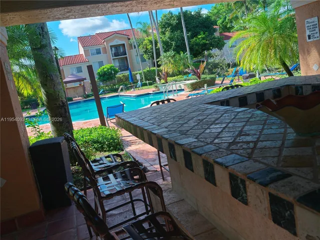 a view of a house with backyard and sitting area