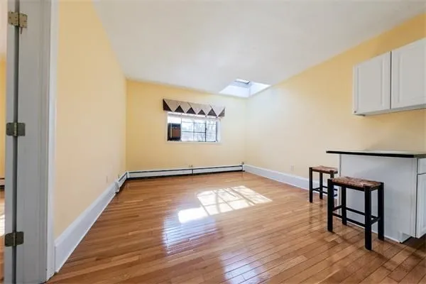 a view of a room with wooden floor and window