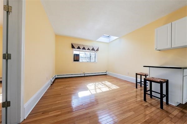 a view of a room with wooden floor and window