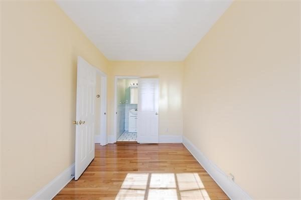 511 Beacon Street, Unit 12 Boston, MA 02215 - Photo 6 of 7 a view of a hallway with wooden floor and a bathroom