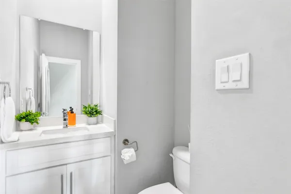 a bathroom with a sink mirror vanity and toilet