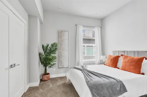a bedroom with a bed and a potted plant