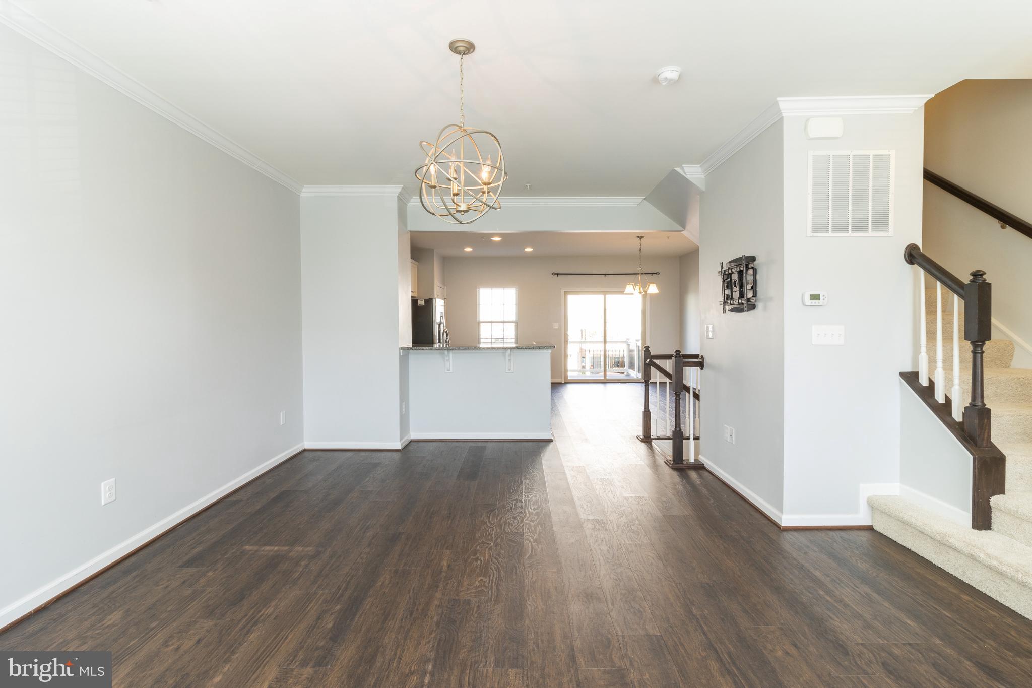 1044 Ramble Run Road Baltimore, MD 21220 - Photo 8 of 37 a view of a kitchen with wooden floor and a chandelier