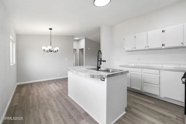 a view of a room with a chandelier fan and wooden floor