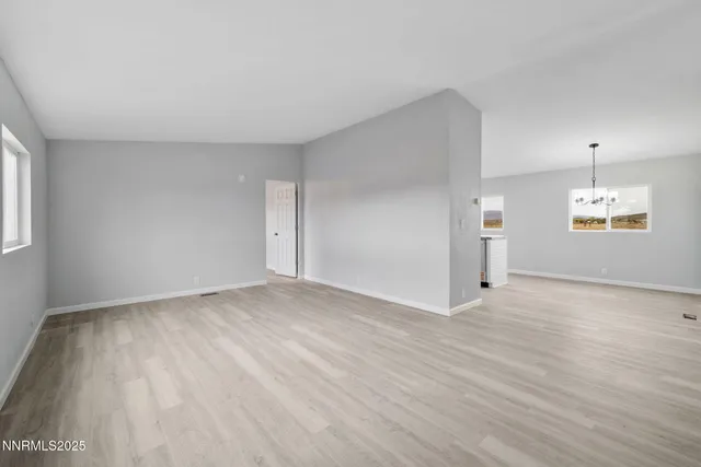 a kitchen with stainless steel appliances granite countertop a sink dishwasher a refrigerator and a stove with wooden floor