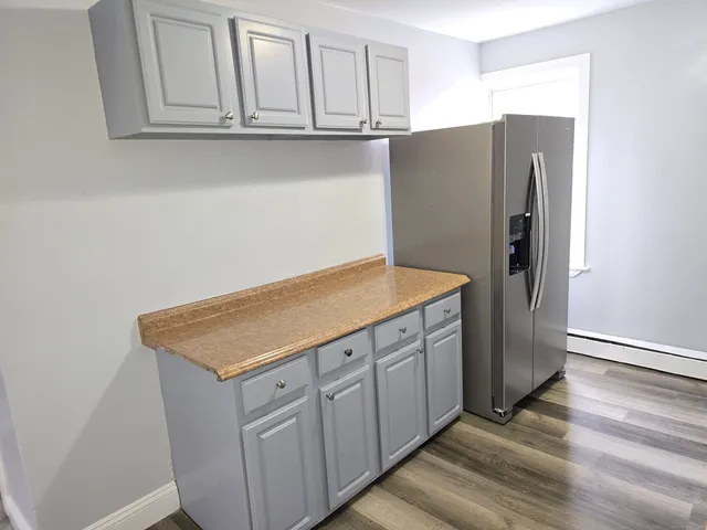 a kitchen with stainless steel appliances cabinets and wooden floor